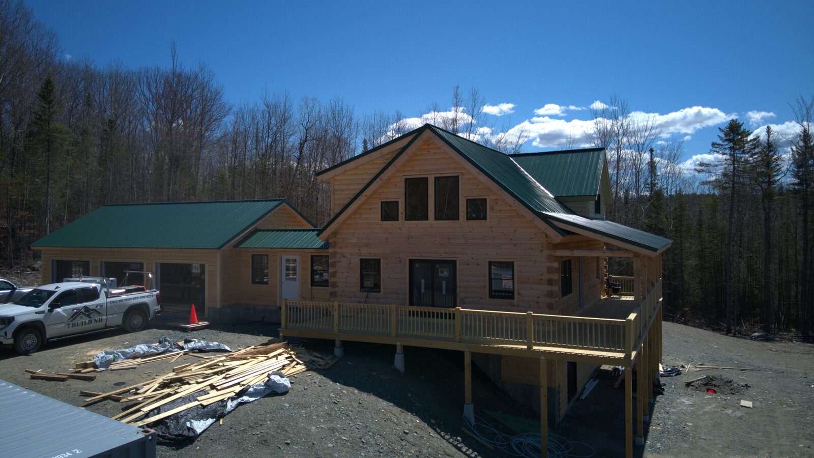 Aerial of a finished log home exterior with green metal roof