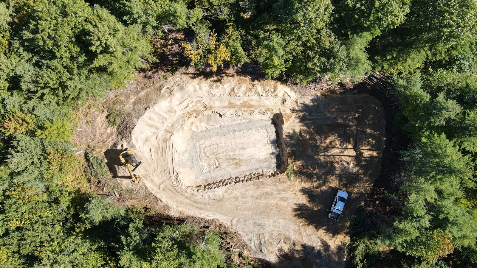 Aerial of an excavated building pad in the woods