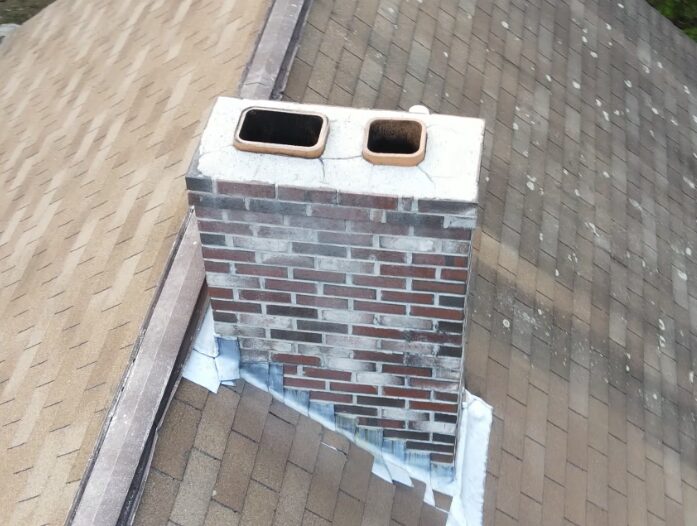 Aerial inspection of a brick chimney crown and flashing